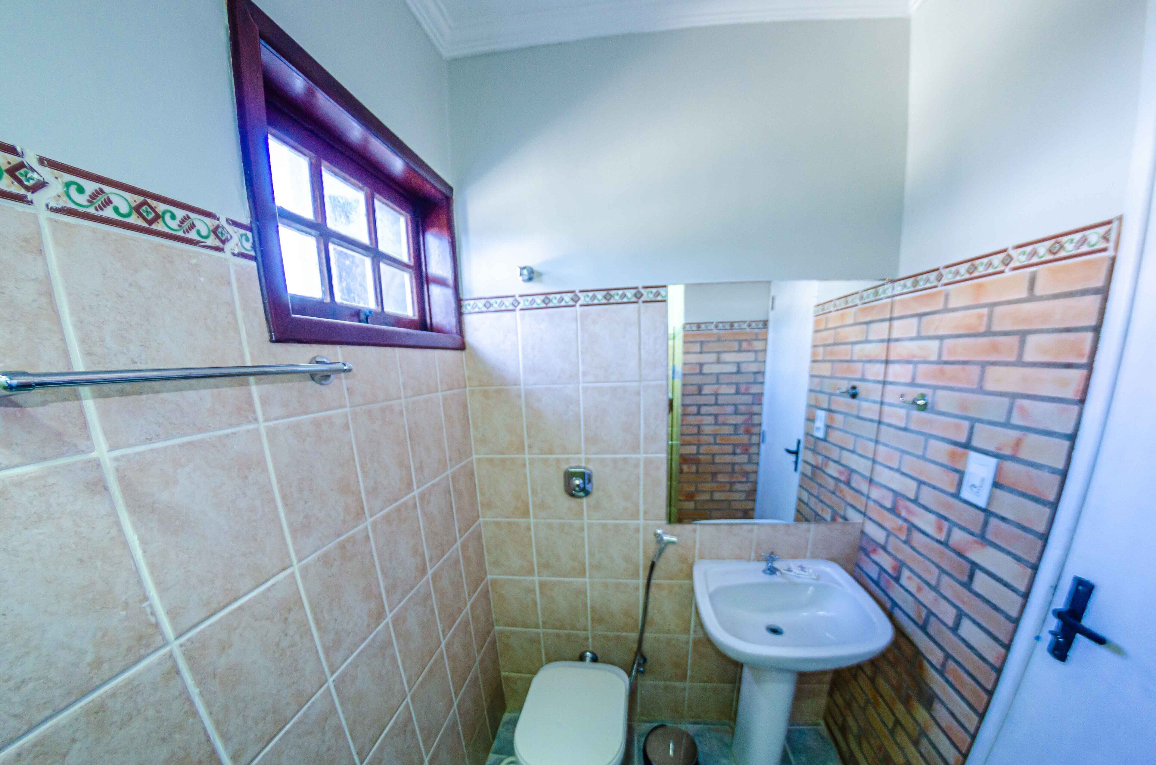 Un baño pequeño con inodoro, lavamanos y ducha.