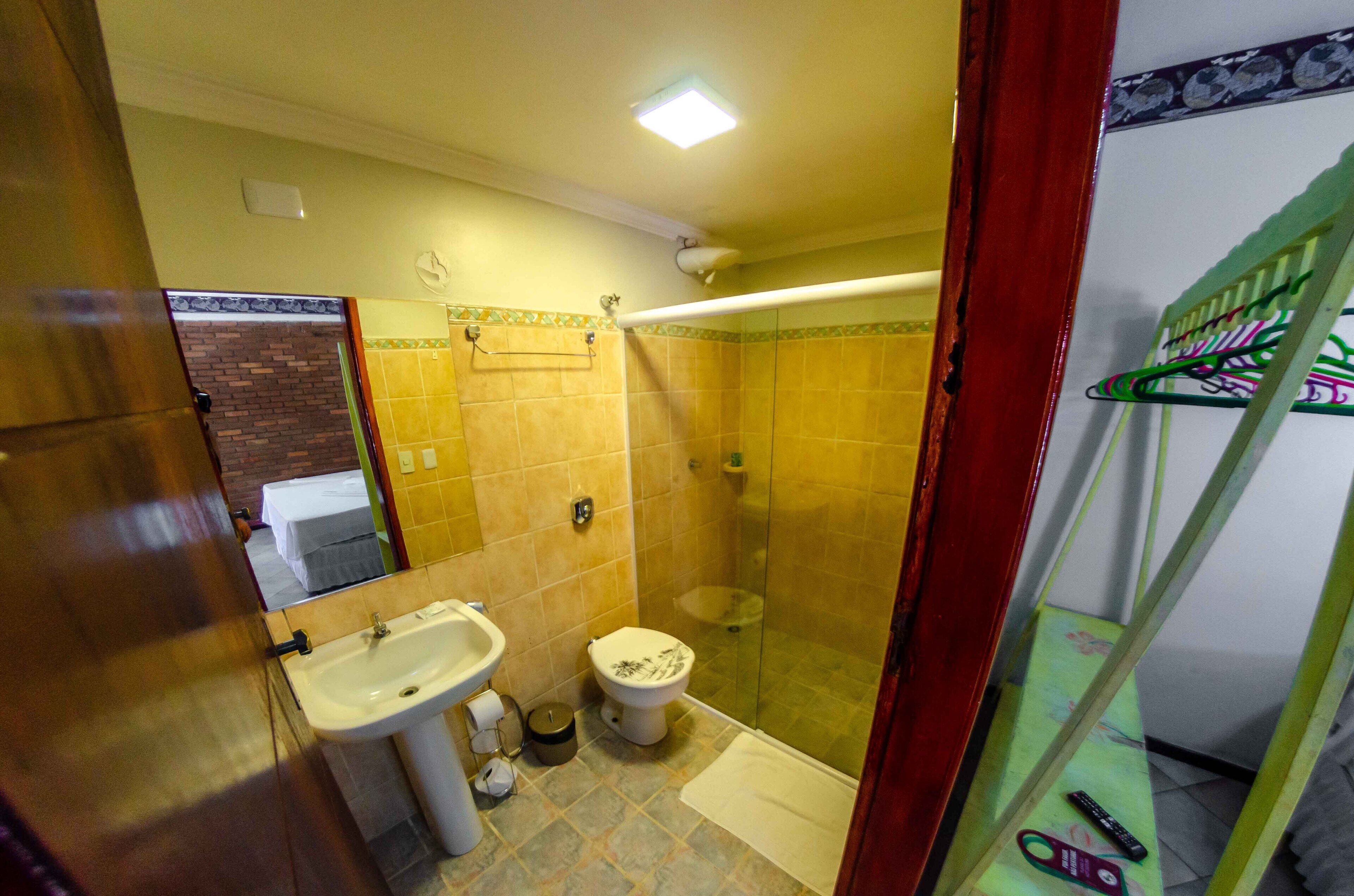 Une salle de bain avec un lavabo, des toilettes et une douche.