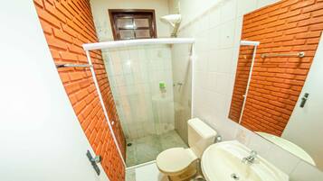 Un baño con inodoro, lavamanos y ducha.