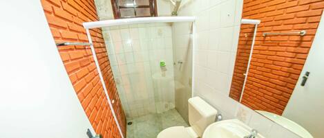 A bathroom with a toilet, sink, and shower.