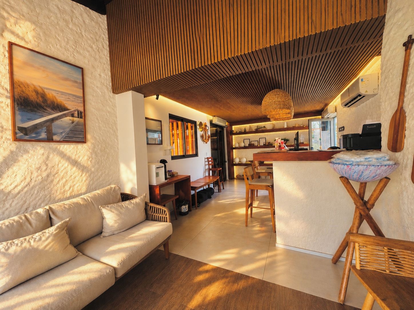 A cozy living area with a sofa, wooden furniture, and a dining space with a central island.