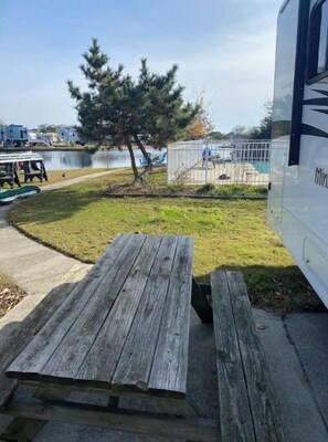 Enjoy a family-friendly getaway with a picnic table and play area nearby, surrounded by a peaceful body of water.