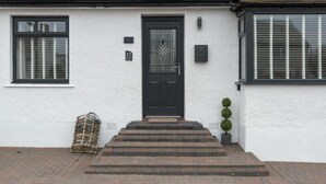 A white building with a black door, numbered 17, and a small staircase leading to the entrance. - Southfield Lodge (Seahouses)