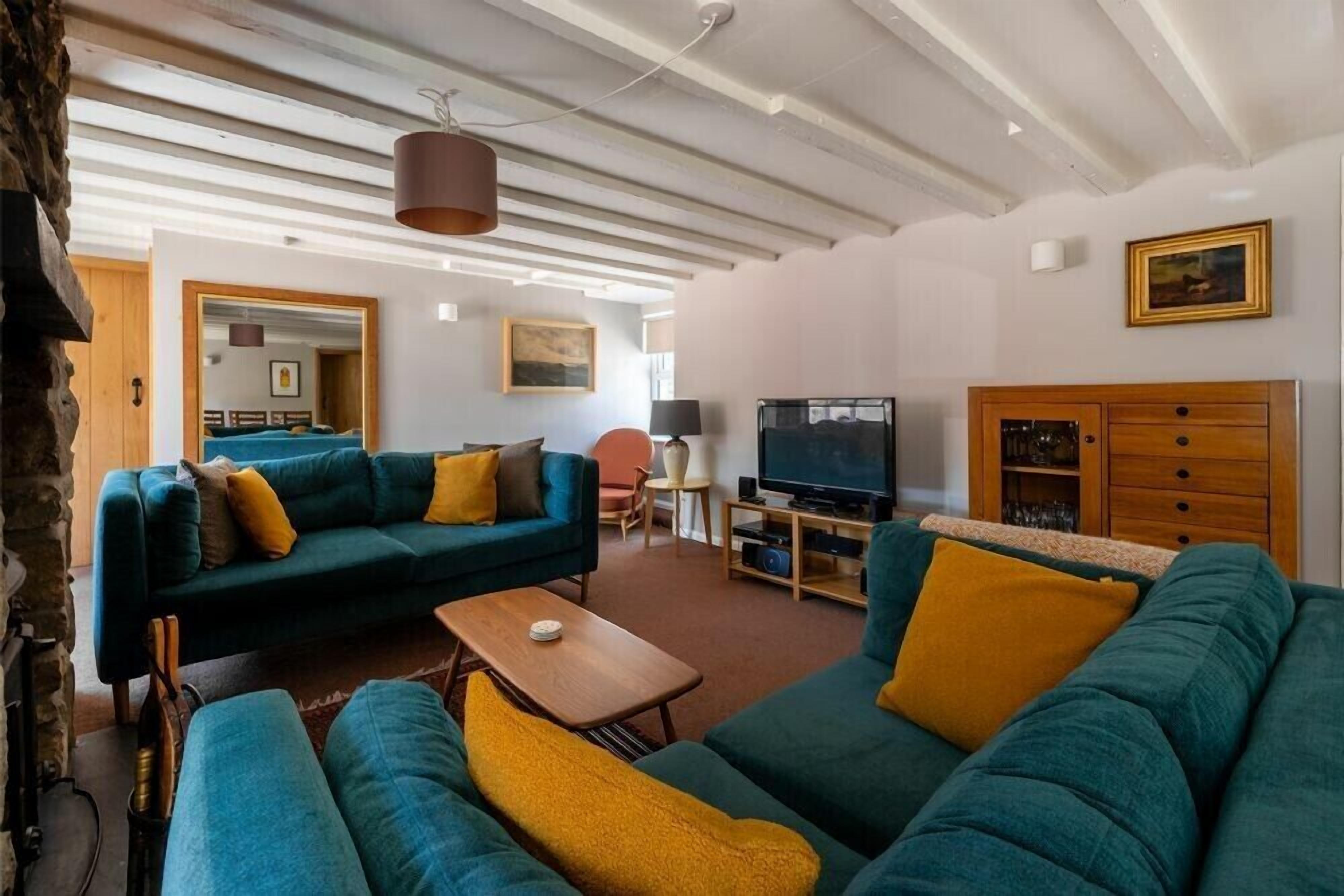 A living room with a sofa set, a television, and a wooden cabinet.