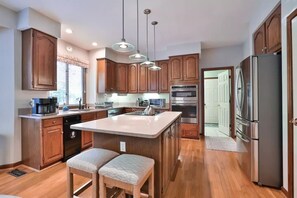 Enjoy cooking in this well-equipped kitchen with a central island, sink, and ample counter space.