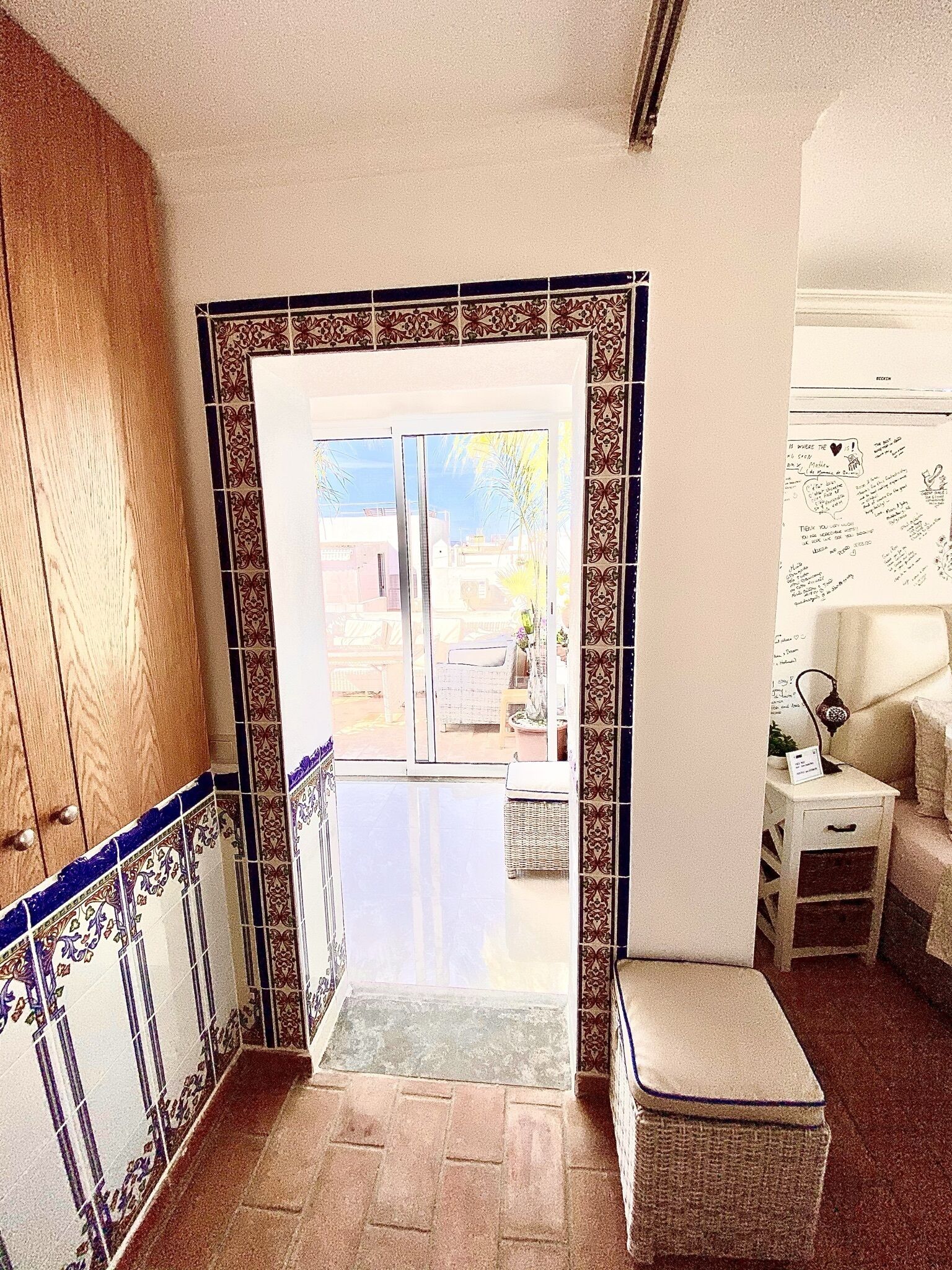 A hallway with a tiled entrance leading to an outdoor area.
