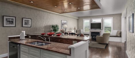 A modern kitchen with granite countertops, a built-in dishwasher, and a dining area with a fireplace.