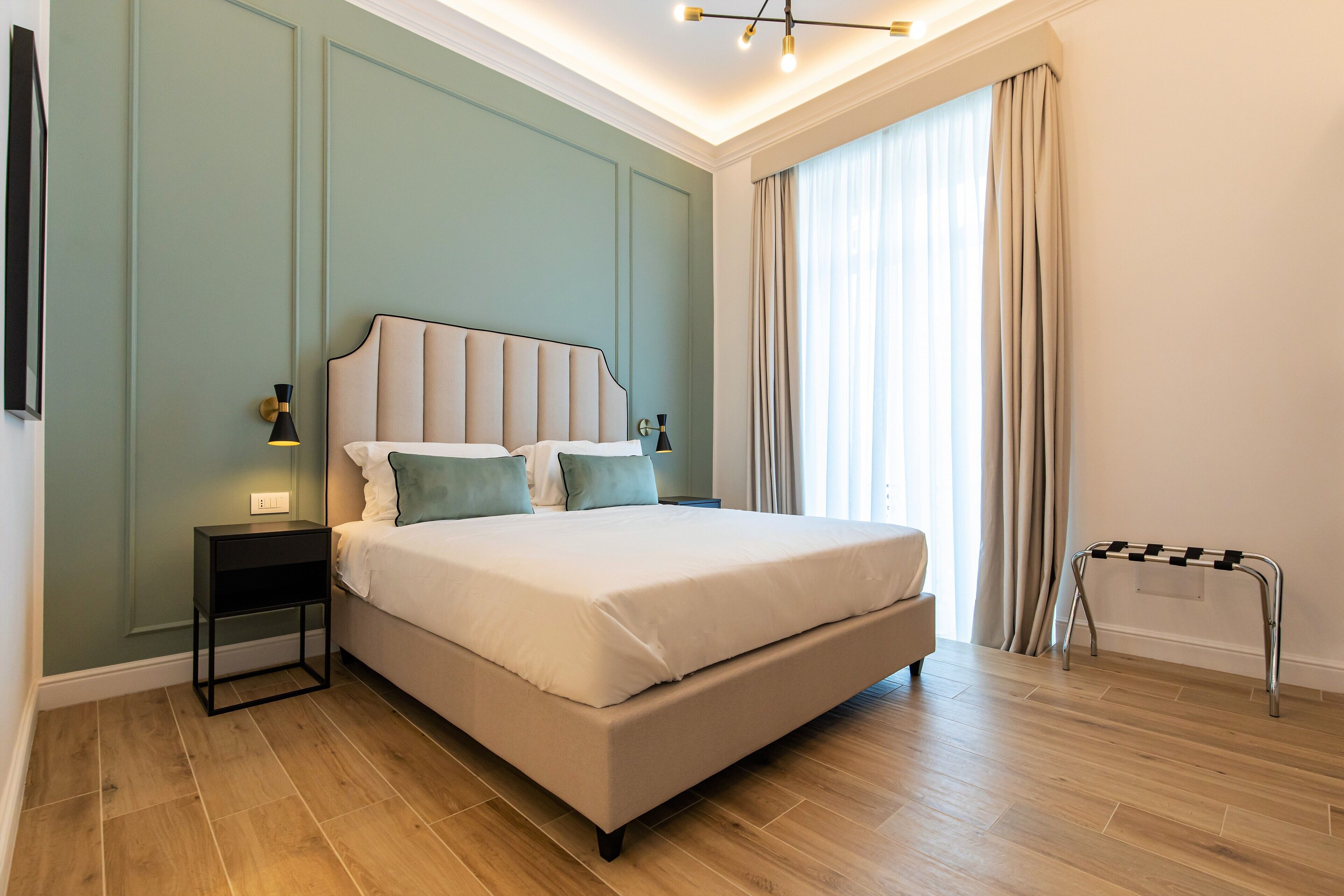 Un dormitorio moderno con una cama grande, una mesita de noche, una lámpara y un radiador.