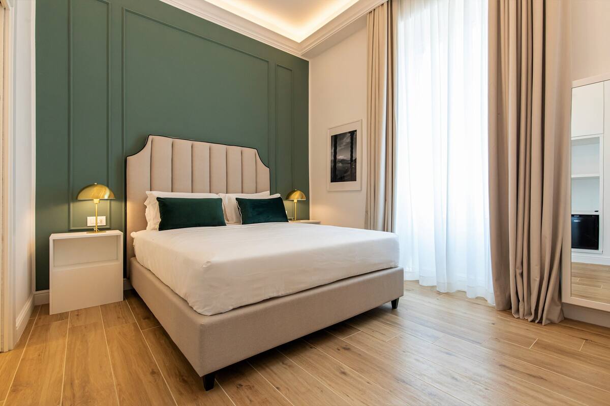A modern bedroom with a large bed, two bedside tables, and a nightstand.