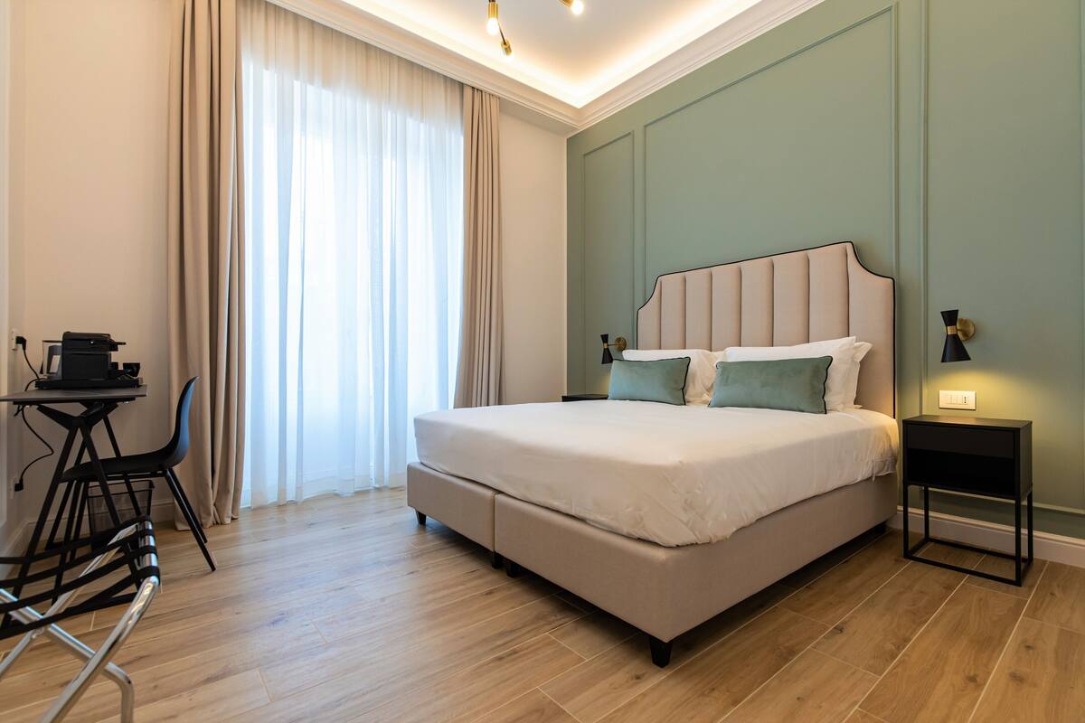 A modern bedroom with a bed, a desk, and a chair.