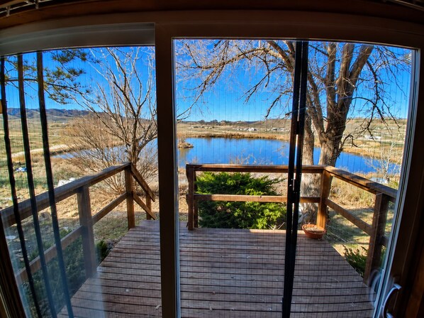 Una terraza de madera con vista a un lago y el paisaje circundante.