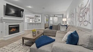 A modern living room with a fireplace, a sofa, and abstract wall art. - North Scottsdale-Luxurious, newly-renovated condo, great location in Kierland (Scottsdale)
