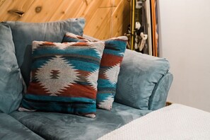 A blue sofa with two patterned throw pillows. - Downtown Bozeman Bungalow - 2 blocks from Main St. (Bozeman)