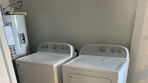A laundry room with two stacked washer and dryer units.