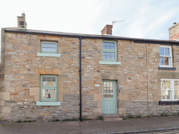 Traditional stone house with a symmetrical facade and evenly spaced windows.