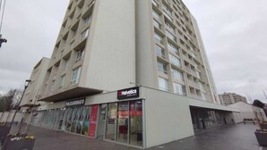 En byggnad med flera våningar, där bottenvåningen inrymmer en butik med namnet ”Helvetica”.