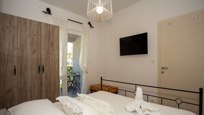 Une chambre à coucher avec un lit, une télévision, une armoire et une porte.