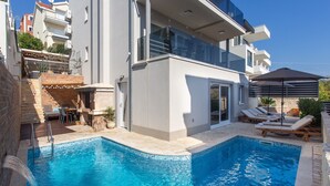 Un bâtiment moderne doté d’une piscine, d’un espace extérieur aménagé et d’un patio couvert.