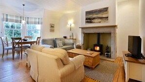 A cozy living room with a fireplace, a sofa, a coffee table, and a television.