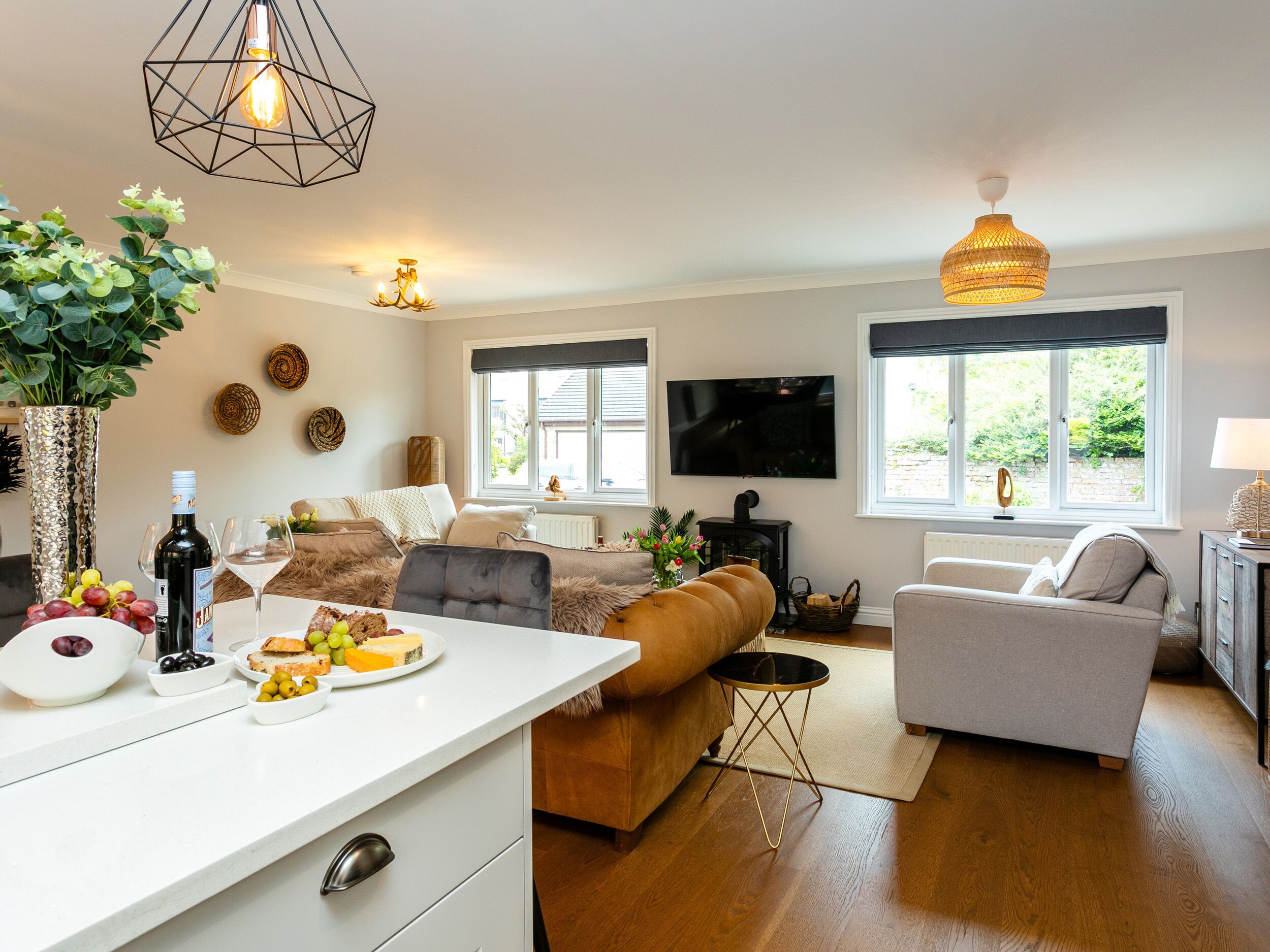 Una sala de estar moderna con un sofá, una mesa de comedor con comida, un televisor y una chimenea.