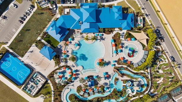 An aerial view of a resort with a large pool, a basketball court, and a water park.