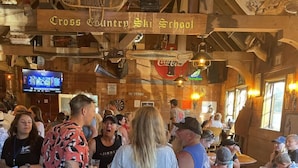A rustic interior with wooden beams and a sign reading "Cross Country Ski School". - Lakeshore Resort (Lakeshore)