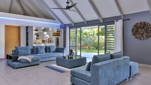 A modern living room with a sectional sofa, a coffee table, and a built-in bookshelf. - Unique luxuous 350sq m Villa with pool, fitness area, home cinema lounge .... (bora bora)
