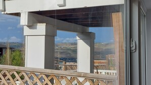 A balcony with a view of a hilly landscape. - Cozy basement suite near the mountains (Cochrane)