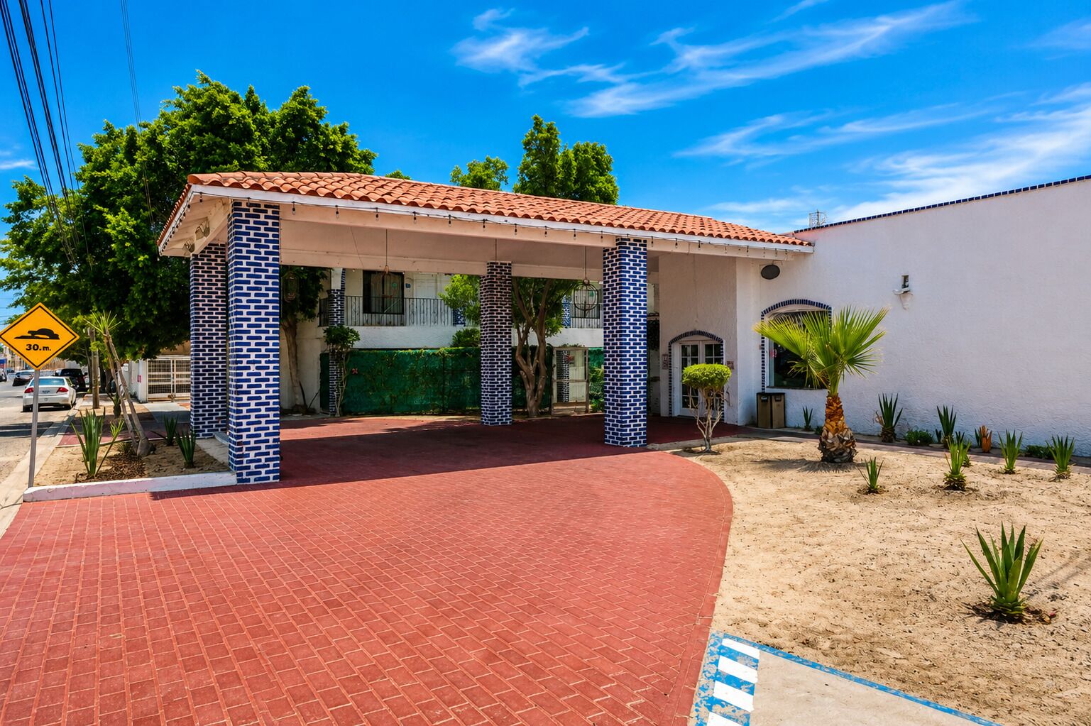 A building with a red-tiled roof, a brick facade, and a covered entrance area.