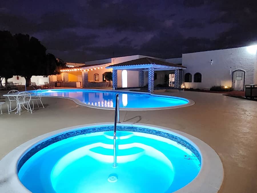 Alberca al aire libre, sombrillas en la alberca y camastros