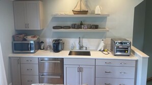 A compact kitchen with a microwave, toaster, sink, and cabinets. - Harbor View Suite
Talbot County License Number STRN-25-58 (Saint Michaels)
