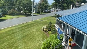A residential building with a blue roof, a front porch with a flag, and a well-maintained lawn. - Harbor View Suite
Talbot County License Number STRN-25-58 (Saint Michaels)
