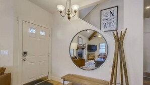 A modern interior with a round mirror, a bench, and a wooden ladder.
