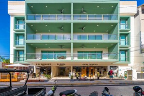 A multi-story building with balconies, a cafe, and a store named 'La Poza'.