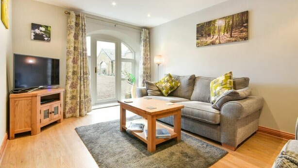 Ein Wohnzimmer mit Fernseher, Sofa und Couchtisch.