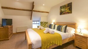 Ein Schlafzimmer mit einem hölzernen Bett, einem Fernseher, einem Heizkörper und einem Bild an der Wand.