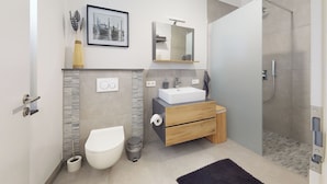 Ein modernes Badezimmer mit Toilette, Waschbecken und Dusche.