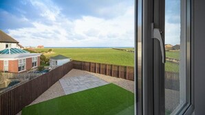 Um quintal com vista para um campo e um prédio.