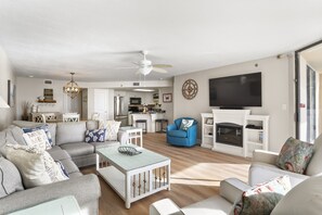 A modern living room with a sofa, coffee table, and a fireplace.