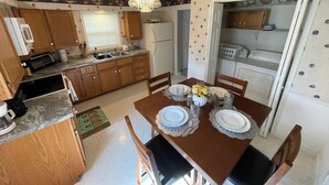 A compact kitchen with wooden cabinets, a microwave, and a refrigerator. - Home in Liberty (Liberty)