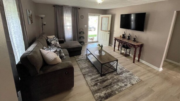 A living room with a sofa, coffee table, and TV. - Home in Liberty (Liberty)