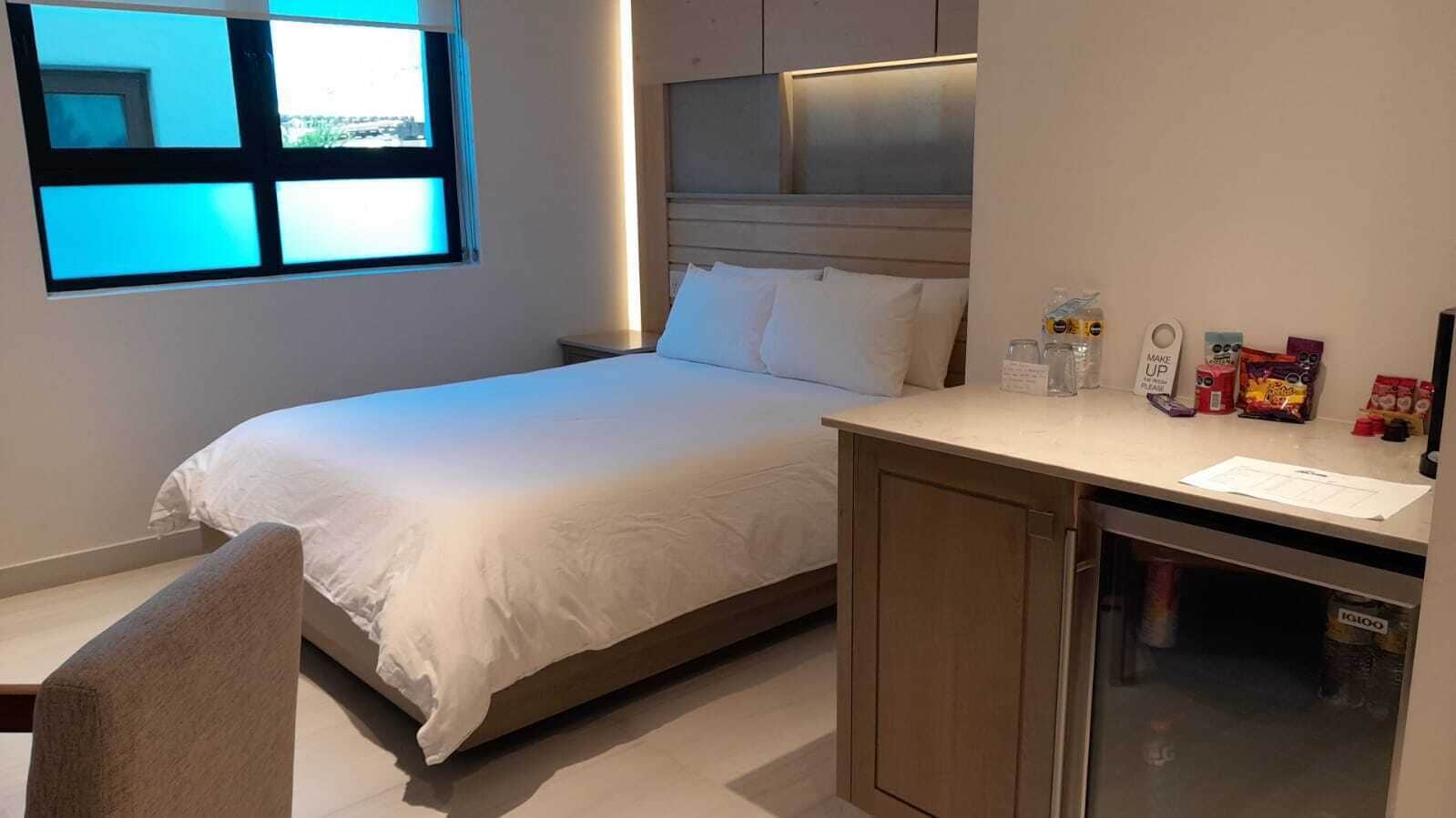Une chambre d’hôtel avec un lit, un bureau et une fenêtre.
