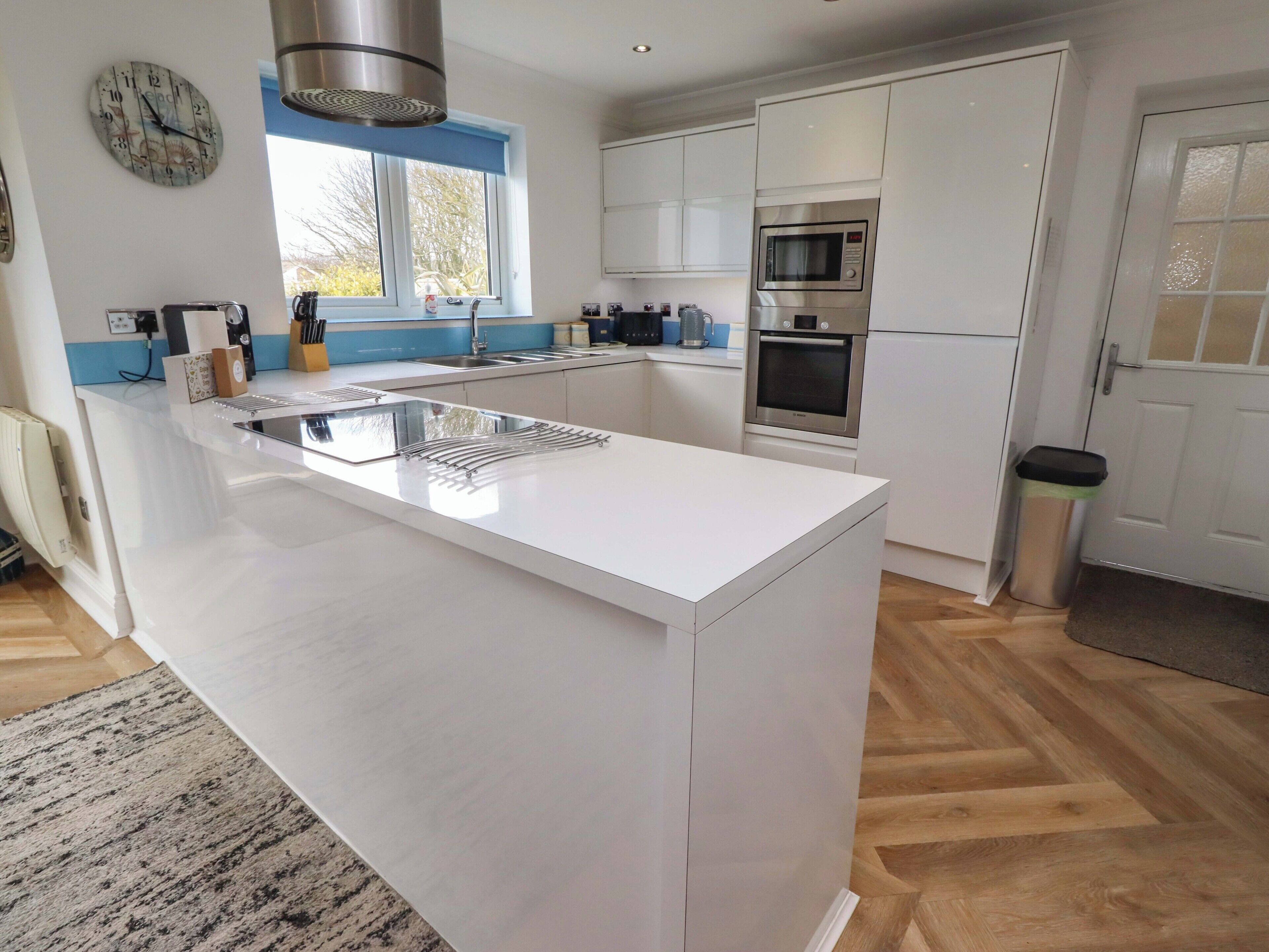 A modern kitchen with a central island, stainless steel appliances, and a window providing natural light.