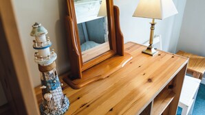 Ein Holztisch mit Spiegel, Lampe und einer Zierleuchtturm.