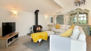 A living room with a TV, sofa, and a fireplace.