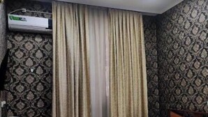 Una camera d'albergo con un letto, una scrivania e un armadio.