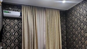 A hotel room with a bed, two bedside tables, a desk, and a patterned wallpaper. - Ikan Hotel twin 3 (Tashkent)