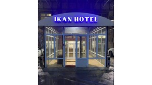 Lasiseinällä varustettu rakennus, jonka yläpuolella on kyltti, jossa lukee ”IKAN HOTEL”.