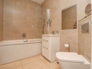 A modern bathroom with a bathtub, a toilet, and a sink. - The Mustard Pot (Morpeth)
