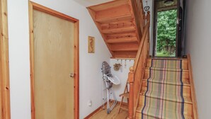 A wooden staircase leading to a second floor with a colorful striped carpet. - Links View (Alnwick)